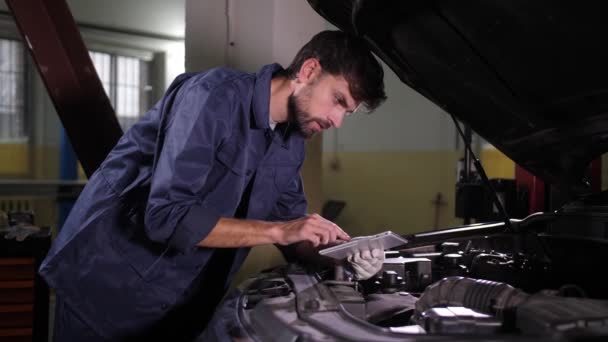 Especialista en reparación de automóviles utilizando tableta PC durante el trabajo — Vídeo de stock