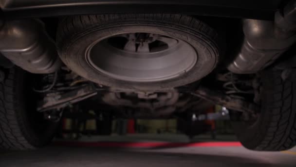 Car on lift in auto repair service, bottom view — 비디오