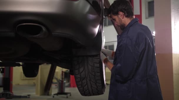 Auto reparação especialista decolando roda do carro — Vídeo de Stock