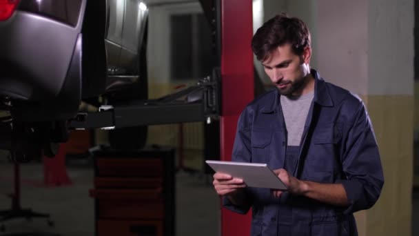 Repairman working on tablet in car workshop — 图库视频影像