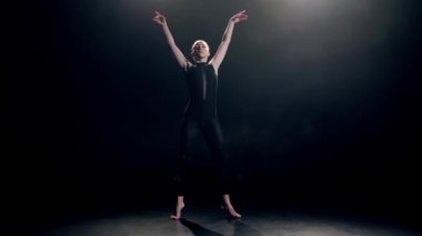 Elegant dancer in black performing modern dance