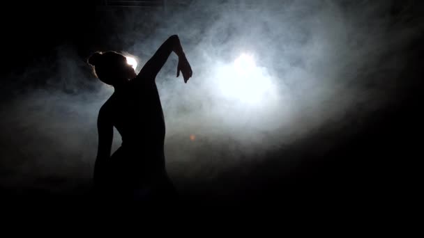 Silhouette of girl dancer raising hand up in dance — Stockvideo