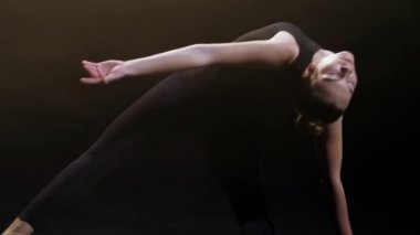 Young woman artist making acrobatic dance elements