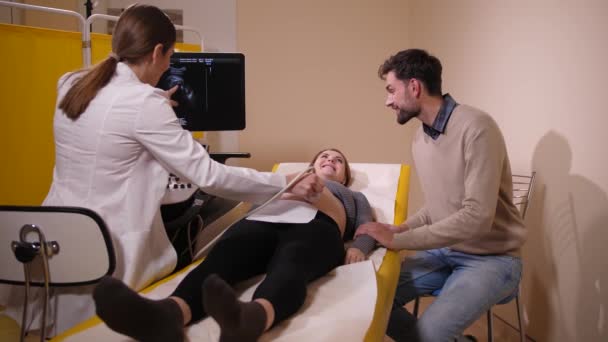 Доктор показывает нерожденного ребенка на ультразвуковом экране — стоковое видео