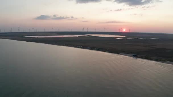 Widok drona Morza Azowskiego i farmy wiatrowej o zachodzie słońca — Wideo stockowe