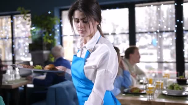 Официантка, подающая блюда посетителям ресторана — стоковое видео