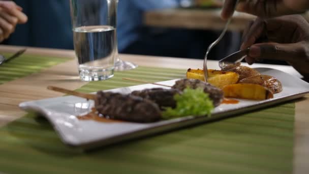 Пластины крупным планом с мясом кебаб и запеченный картофель — стоковое видео