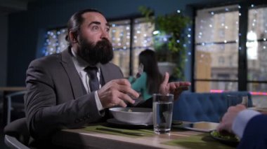 Yeme portresi, iş yemeğinde konuşan adam.