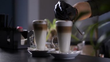 Kahve bardağına pipet koyan bir barmen.