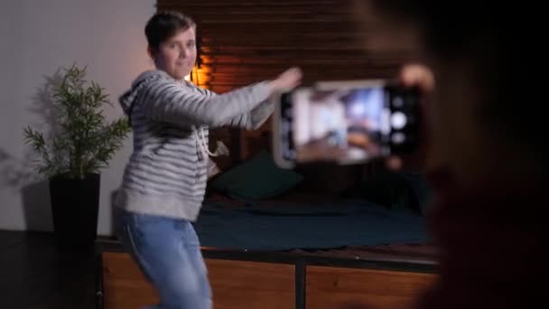 Genç çocuk telefonda video çekimi için dans ediyor. — Stok video