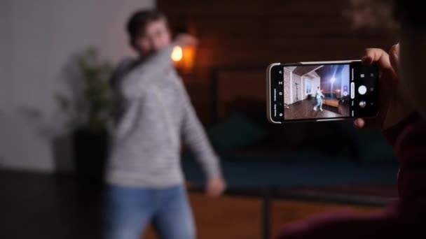 Mobiltelefon i handen fotografering video av dansande pojke — Stockvideo