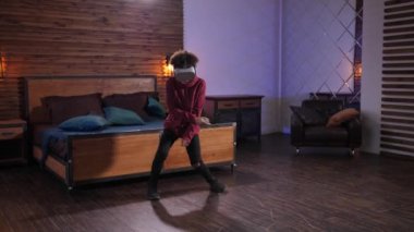 Evde VR gözlükleriyle dans eden mutlu ırk çocuğu.