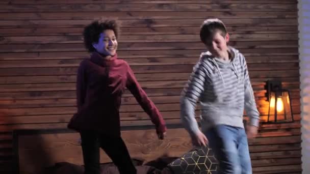 Divertidos adolescentes bailando en la cama en la habitación doméstica — Vídeos de Stock