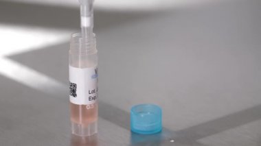 Bilim adamı şişeden sıvı almak için pipeti kullanıyor.