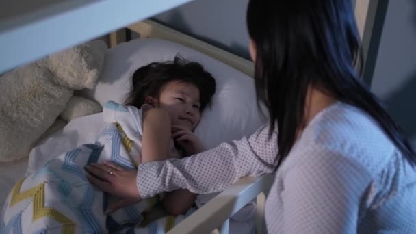 Liefdevolle aziatische moeder zoenen dochter 's nachts — Stockvideo