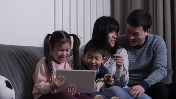 Happy asian family watching cartoons on tablet pc — Stock Video