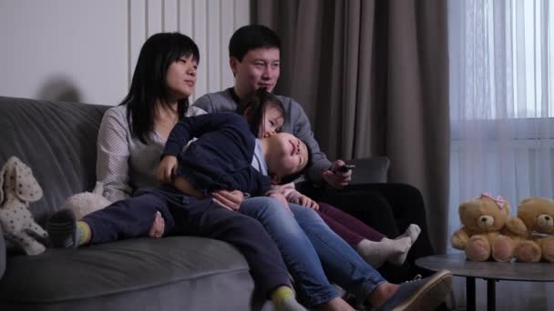 Heureuse famille chinoise avec des enfants regardant la télévision à la maison — Video