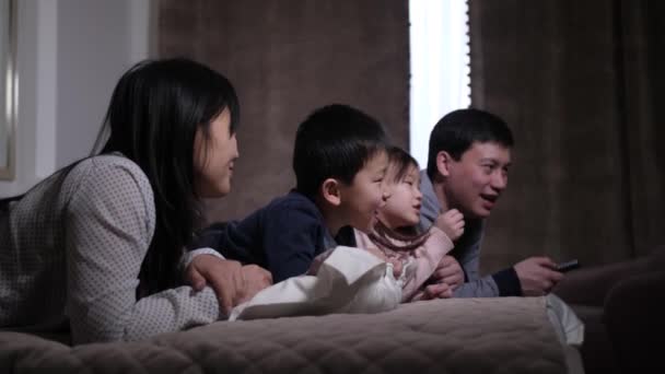 Joyful aziatische familie met kinderen kijken film op TV — Stockvideo