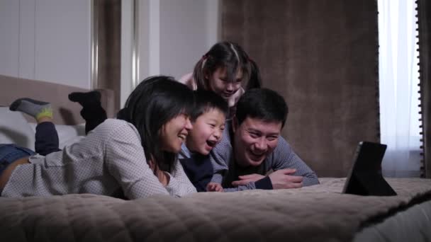 Lachen aziatische familie kijken komedie op tablet pc — Stockvideo