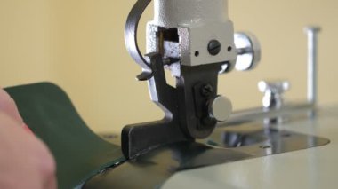 Deri işçiliğinin kenarlarını işleyen kadın elleri