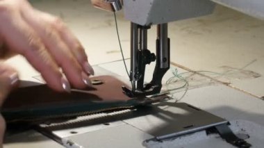 Cüzdanına fermuar diken kadın deri işçisi.