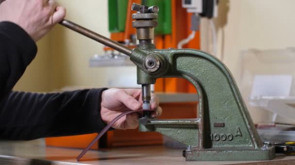 Handwerkerhände stechen Nieten in Leder — Stockvideo