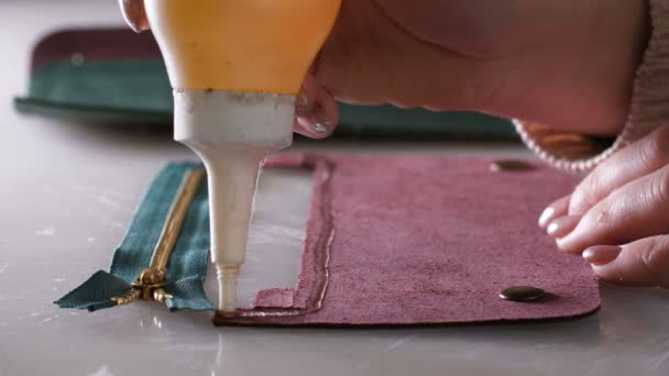 Handwerkerhände beim Auftragen von Klebstoff für Brieftasche — Stockvideo