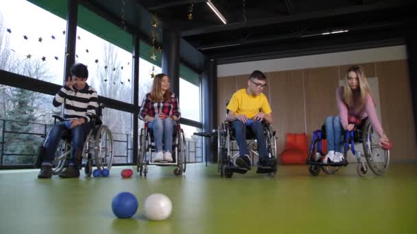 Pessoas em cadeiras de rodas desfrutando de jogo boccia dentro de casa — Vídeo de Stock