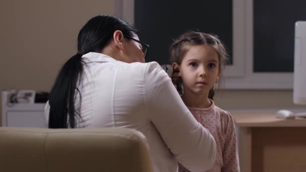 Linda niña preescolar durante el examen de la audición — Vídeos de Stock