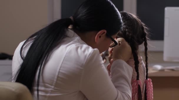 Pediatrician examining ears of joyful little girl — Stock Video