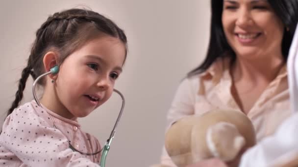 Linda chica usando estetoscopio en la oficina de médicos — Vídeos de Stock