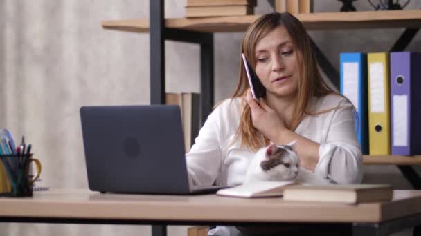 Egy nő portréja, aki munka közben telefonál. — Stock videók