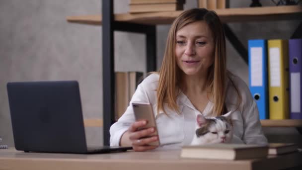 Mulher sorridente se divertindo nas mídias sociais no trabalho — Vídeo de Stock