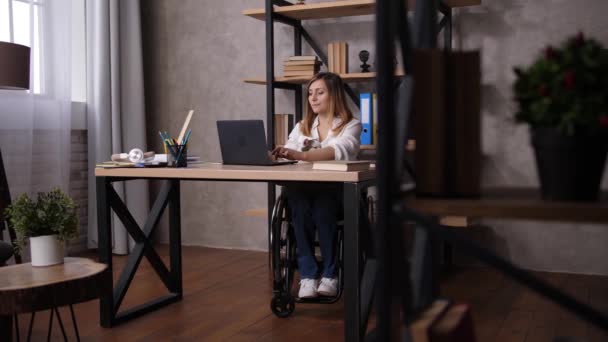 Žena na invalidním vozíku protahování během práce doma — Stock video