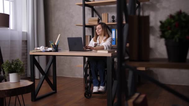 Femme en fauteuil roulant étirant pendant le travail à la maison — Video