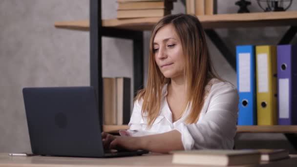 Втомилася від роботи на ноутбуці жінка розтягується — стокове відео