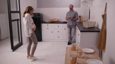 Hamile kadın, kocasının önünde gösteriş yapıyor.