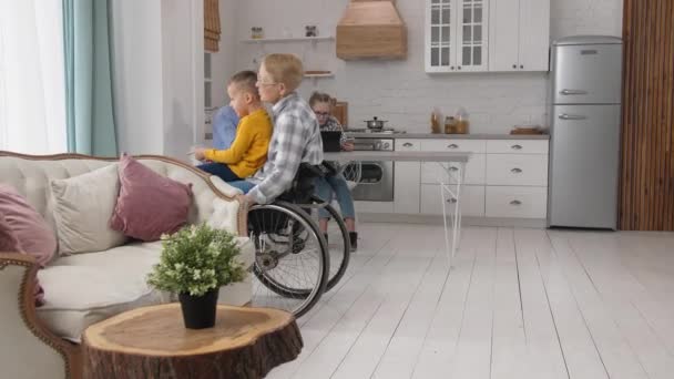 Tekerlekli sandalyede torunuyla dolaşan engelli bir büyükanne. — Stok video