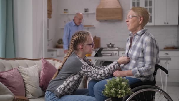 Vnučka pomáhá ochrnutý babičky šaty — Stock video