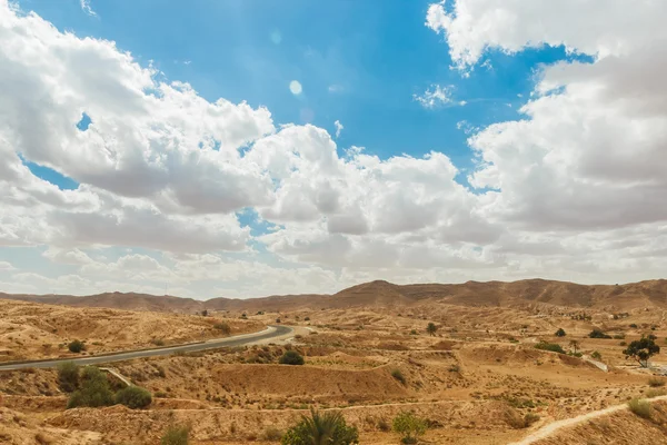 Weg passeert rotsachtige Saharawoestijn, Tunesië. — Stockfoto