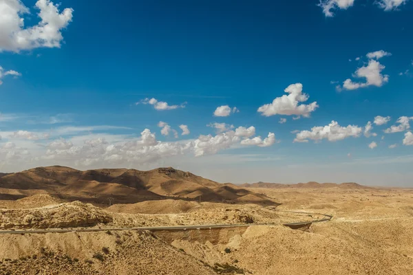 Weg passeert rotsachtige Saharawoestijn, Tunesië. — Stockfoto