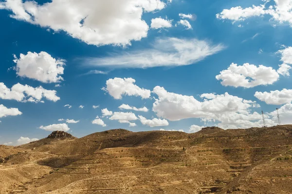 Uitzicht op de bergen in de woestijn. Toeristen op de top van een heuvel. Tunesië. — Stockfoto