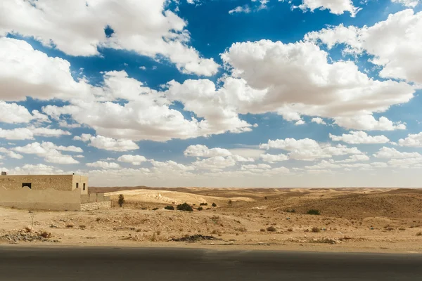 Weg passeert rotsachtige Saharawoestijn, Tunesië. — Stockfoto