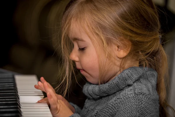 Mała dziewczynka grający na klawiszach fortepianu — Zdjęcie stockowe