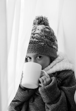 Sevimli küçük bir kızın moda kış giysileri içinde siyah-beyaz fotoğraf