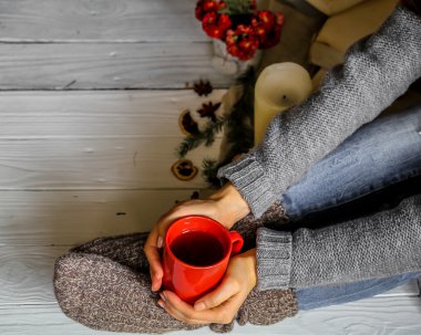 Bir fincan çay ile çoraplı kızın ayakları sıcak ve rahat, kavramı