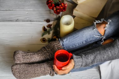 Bir fincan çay ile çoraplı kızın ayakları sıcak ve rahat, kavramı