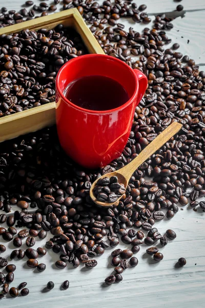 Copo vermelho com grãos de café — Fotografia de Stock