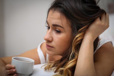 güzel genç kız yatakta bir fincan