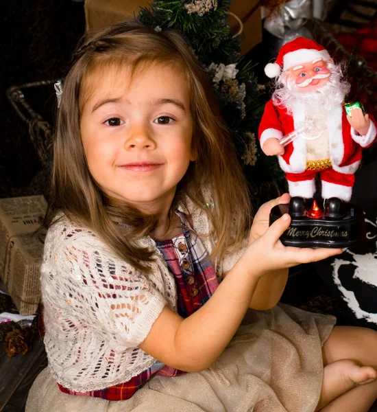 Petite fille mignonne avec un jouet Père Noël dans les mains — Photo